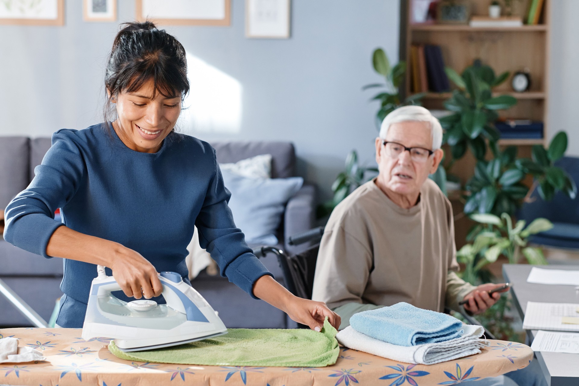 Housekeeper helping senior man with home duties